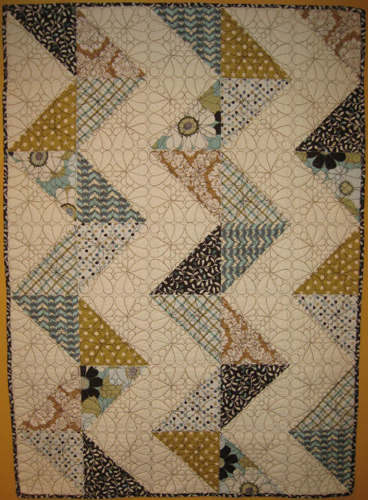 There are 2 embroidery options with the Raising Daisies design! This is the Alayna quilt done in a zigzagged layout. There are so many options with this design.